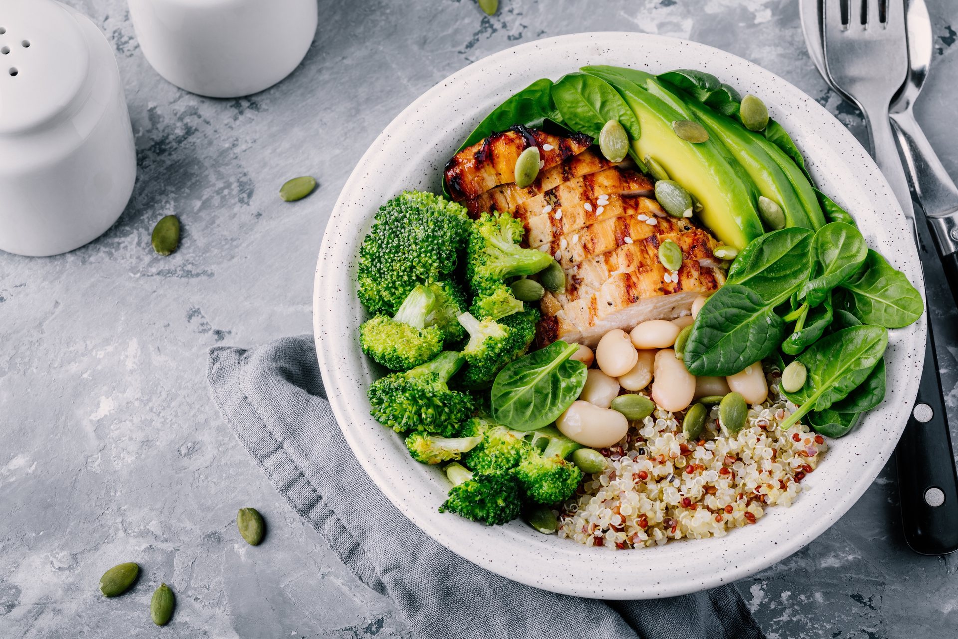 A protein bowl with grilled chicken, white beans, quinoa, broccoli, spinach and avocado